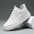White sneaker with textured sole and geometric pattern, modern casual footwear on gray background