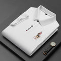 Folded white polo shirt with embroidered horse rider and watch on dark background