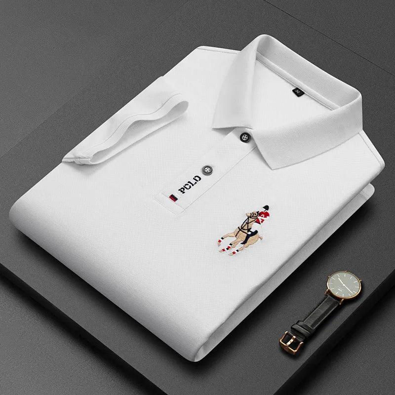 Folded white polo shirt with embroidered horse rider and watch on dark background