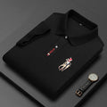 Folded black polo shirt with embroidered horse and rider, luxury watch beside it