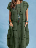Woman wearing loose green midi dress with pockets and abstract black print