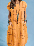 Woman wearing a loose-fit orange midi dress with geometric print and pockets, styled with jewelry.