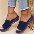 Woman wearing blue orthopedic sandals with woven upper and light-wash jeans