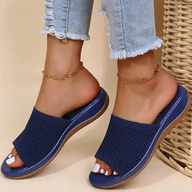 Woman wearing blue orthopedic sandals with woven upper and light-wash jeans