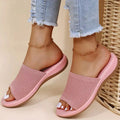 Pink orthopedic women's sandals with woven upper, worn with frayed hem jeans