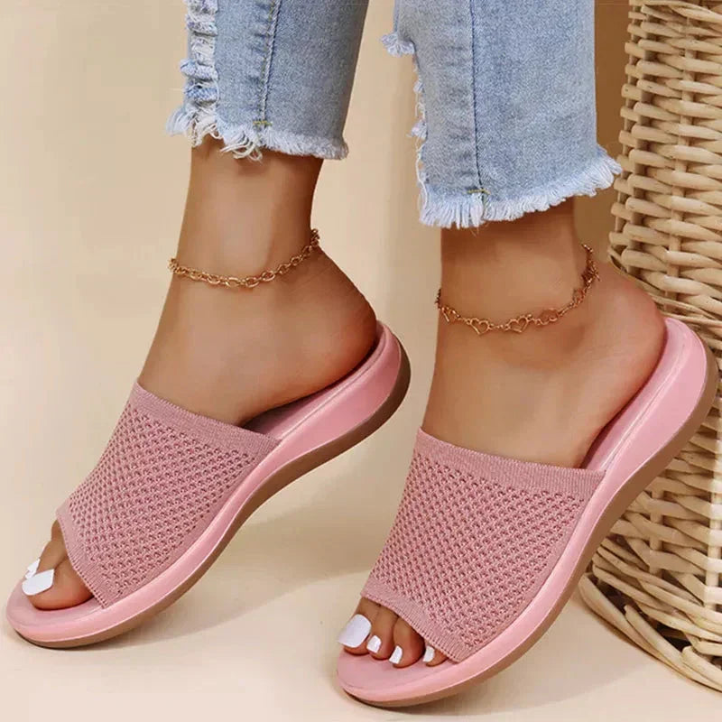 Pink orthopedic women's sandals with woven upper, worn with frayed hem jeans