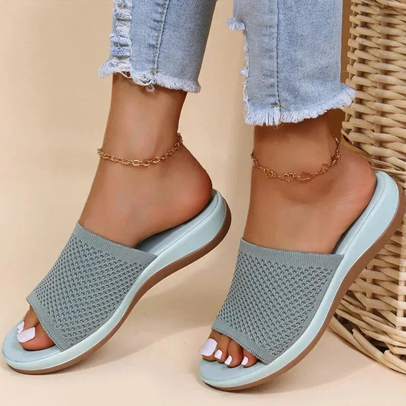 Light blue orthopedic women's sandals with knitted upper, worn with frayed jeans